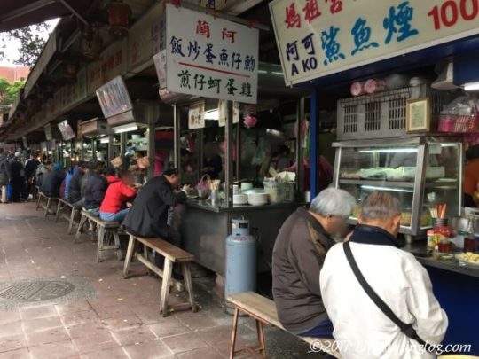 台湾の慈聖宮にあるグルメスポットで食事をする人々