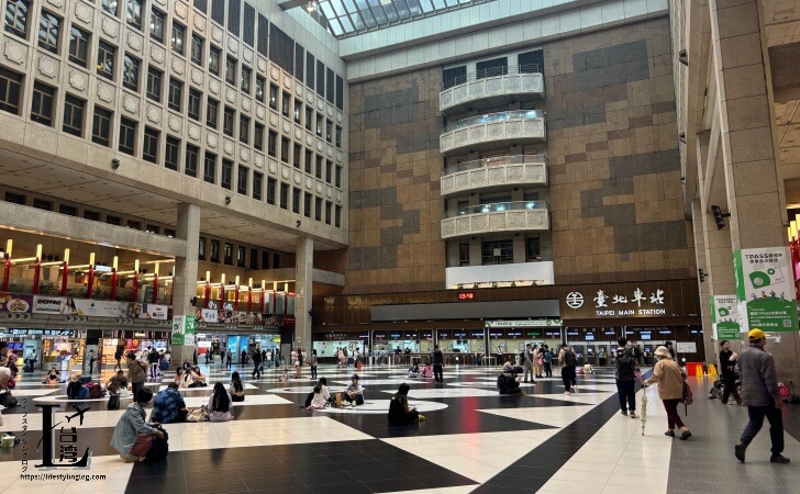 台北メインステーションのホールで座っている人たち