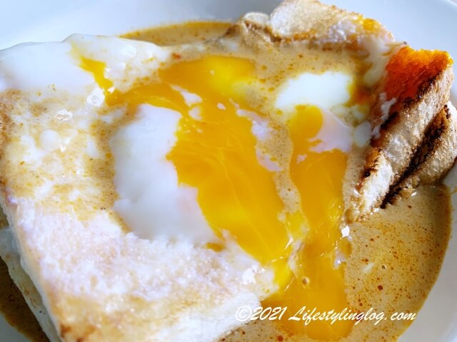 何九海南茶店（Ho Kow Hainam Kopitiam）の咖喱+生熟蛋烤面包 Half Boiled Egg Curry Banjir Toastの卵を潰したところ